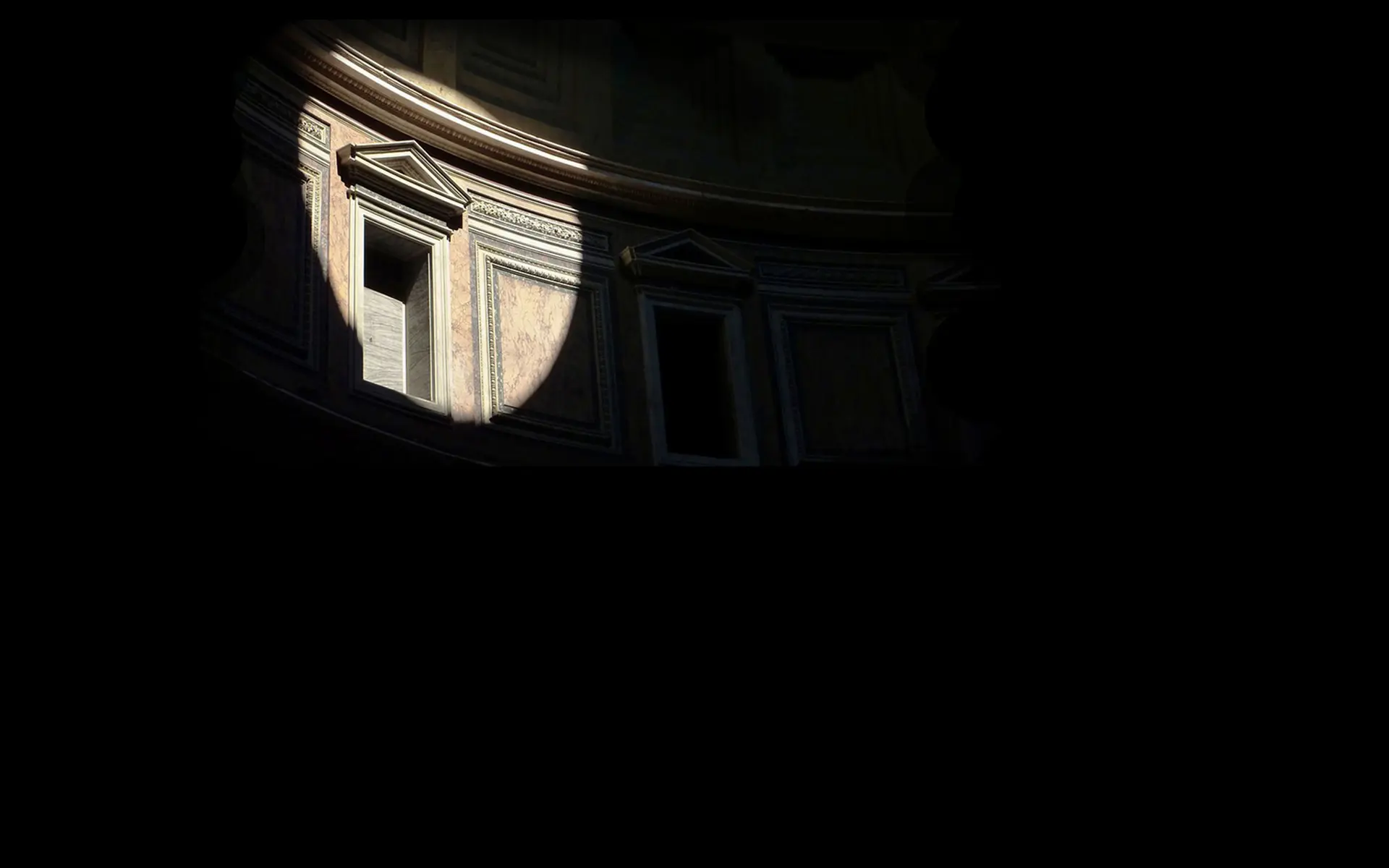 Shaft of sunlight illuminating the coffered interior wall of a Roman rotunda