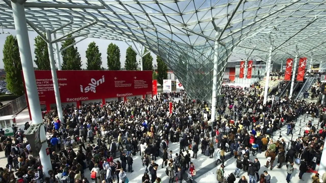 Crowd under a glass lattice canopy at a trade fair entrance