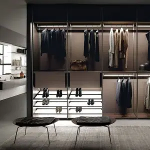 Boffi walk-in wardrobe with backlit hanging rails, shoe drawers and two round stools