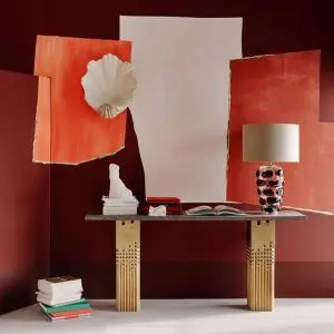 Red-toned still life with torn paper backdrops, a ceramic shell and a console table