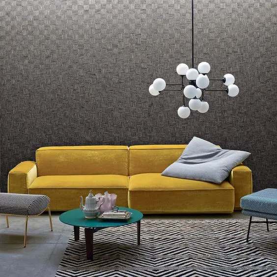 Mustard velvet sofa under a spherical bubble chandelier with a green round coffee table