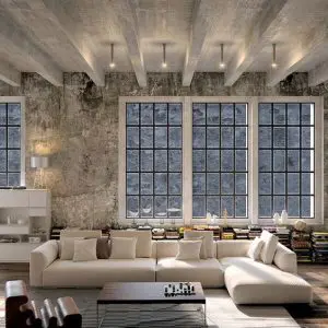 Loft living room with concrete beams, exposed brick wall, tall windows and a beige sectional