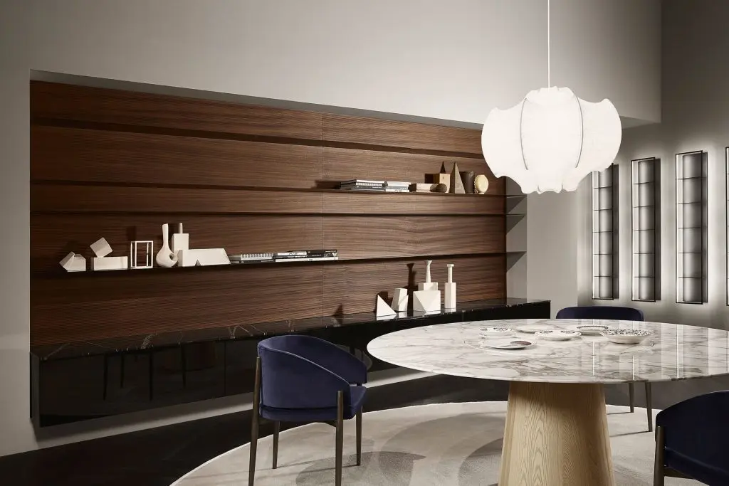 Dining area with round marble table, blue velvet chairs and a large bubble pendant lamp