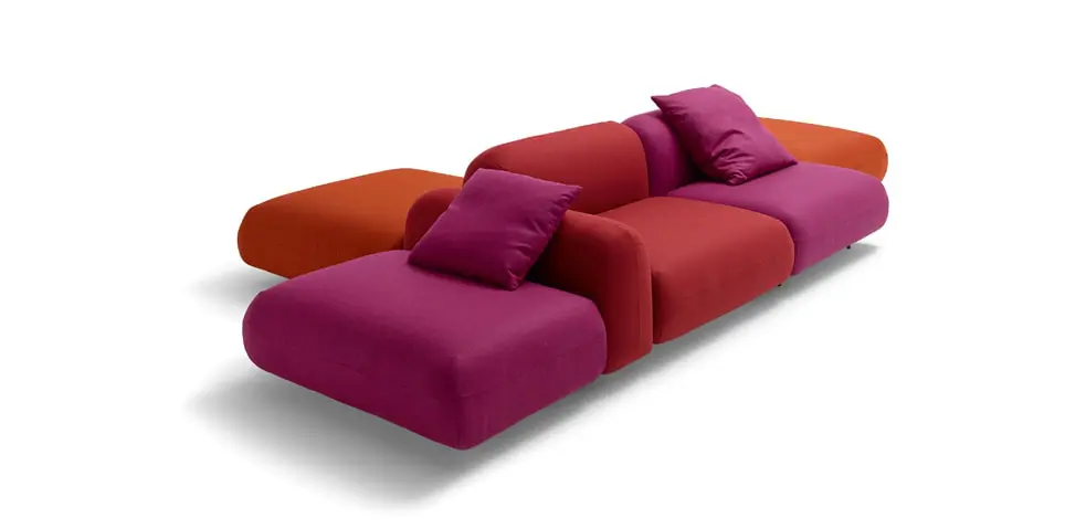 Magenta and orange modular sofa with matching square cushions on a white background