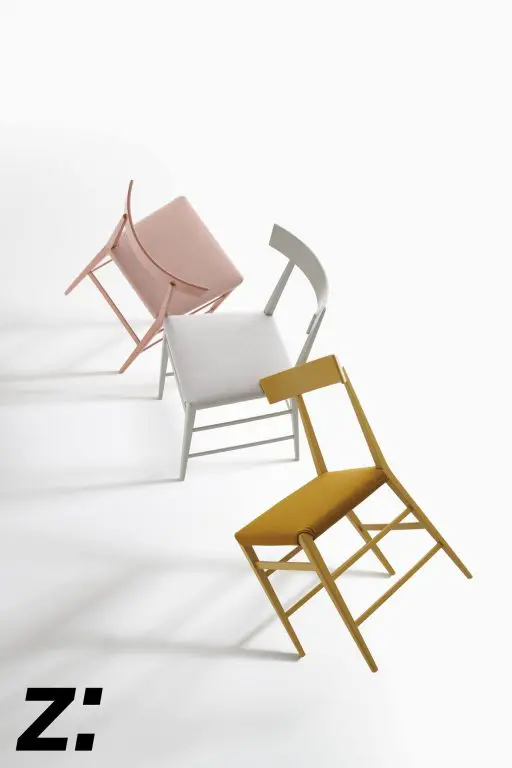 Three folding chairs in pink, white and mustard shown mid-fold on a white background
