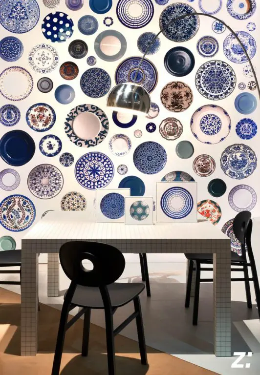 Wall densely covered with blue and white decorative plates above a tiled dining table