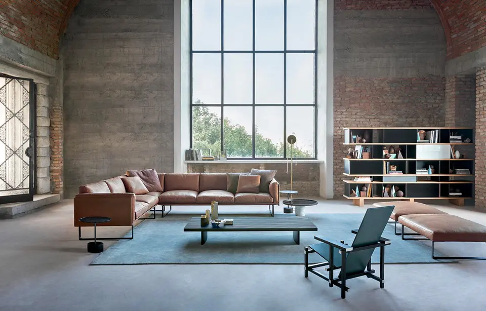 Industrial loft living room with leather sofa, coffee table and large arched window