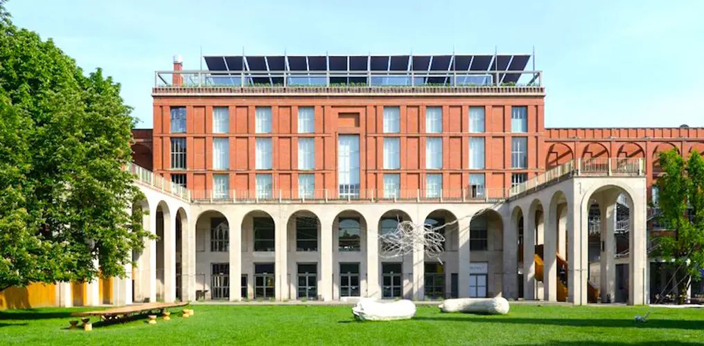 brick building with rooftop solar panels and an arcaded courtyard