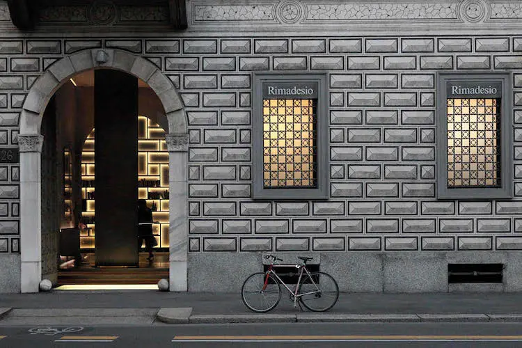 Rimadesio storefront entrance on a Milan street with a parked bicycle