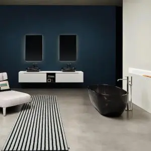 Bathroom with a black oval freestanding tub, white floating double vanity and a navy blue wall