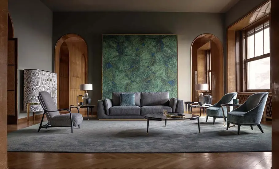Living room with a grey sofa, patterned green artwork panel and dark green velvet armchairs on a grey rug
