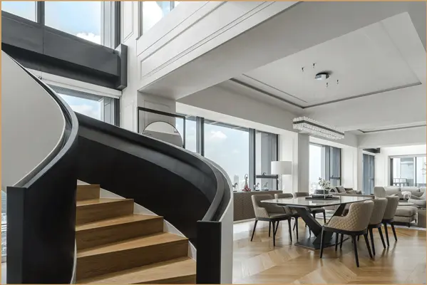 Penthouse dining area beside a curved staircase with skyline views