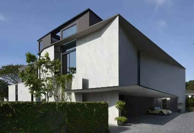Angular gray modern villa exterior with cantilevered roof and covered car porch