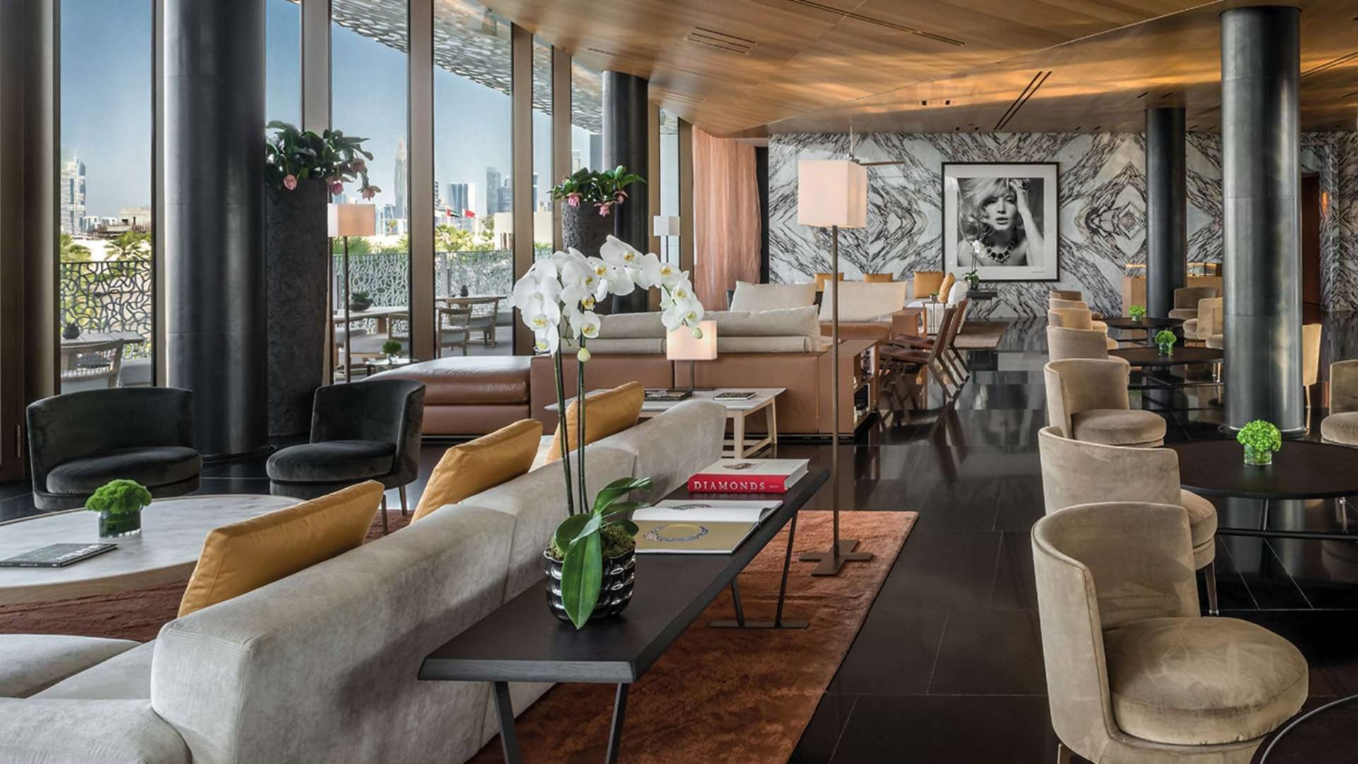 interior image of a lobby with Italian furniture in dubai together with lamps, flowers, and large windows