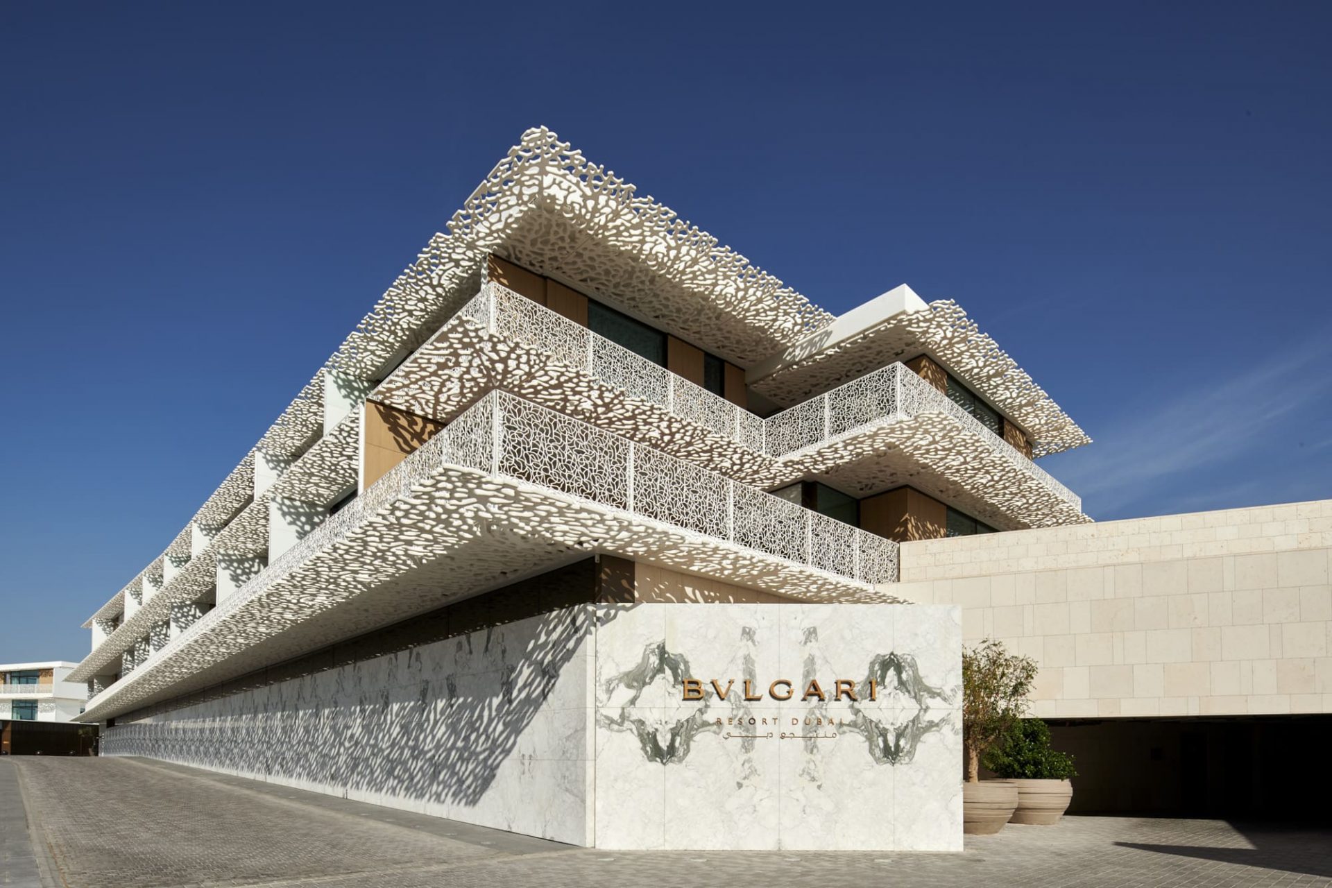 white building with architectural shadows and blue sky