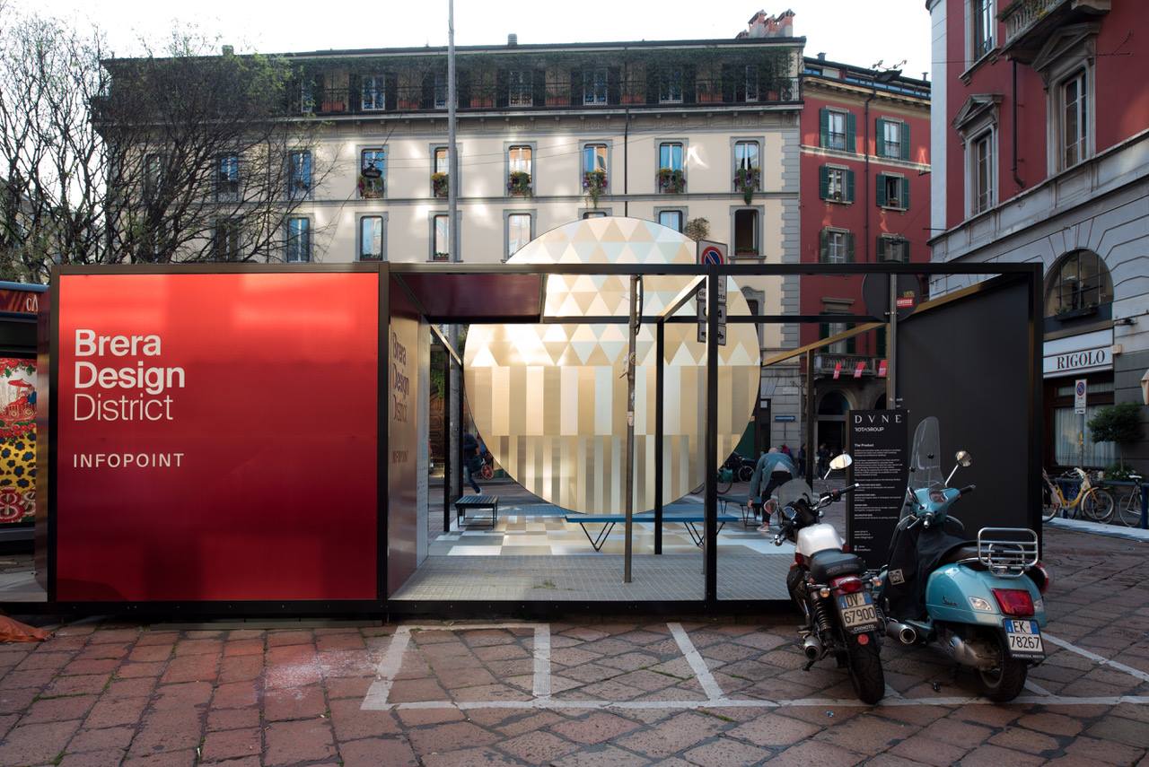 outdoor center in milan with historic buildings surrounding an info point