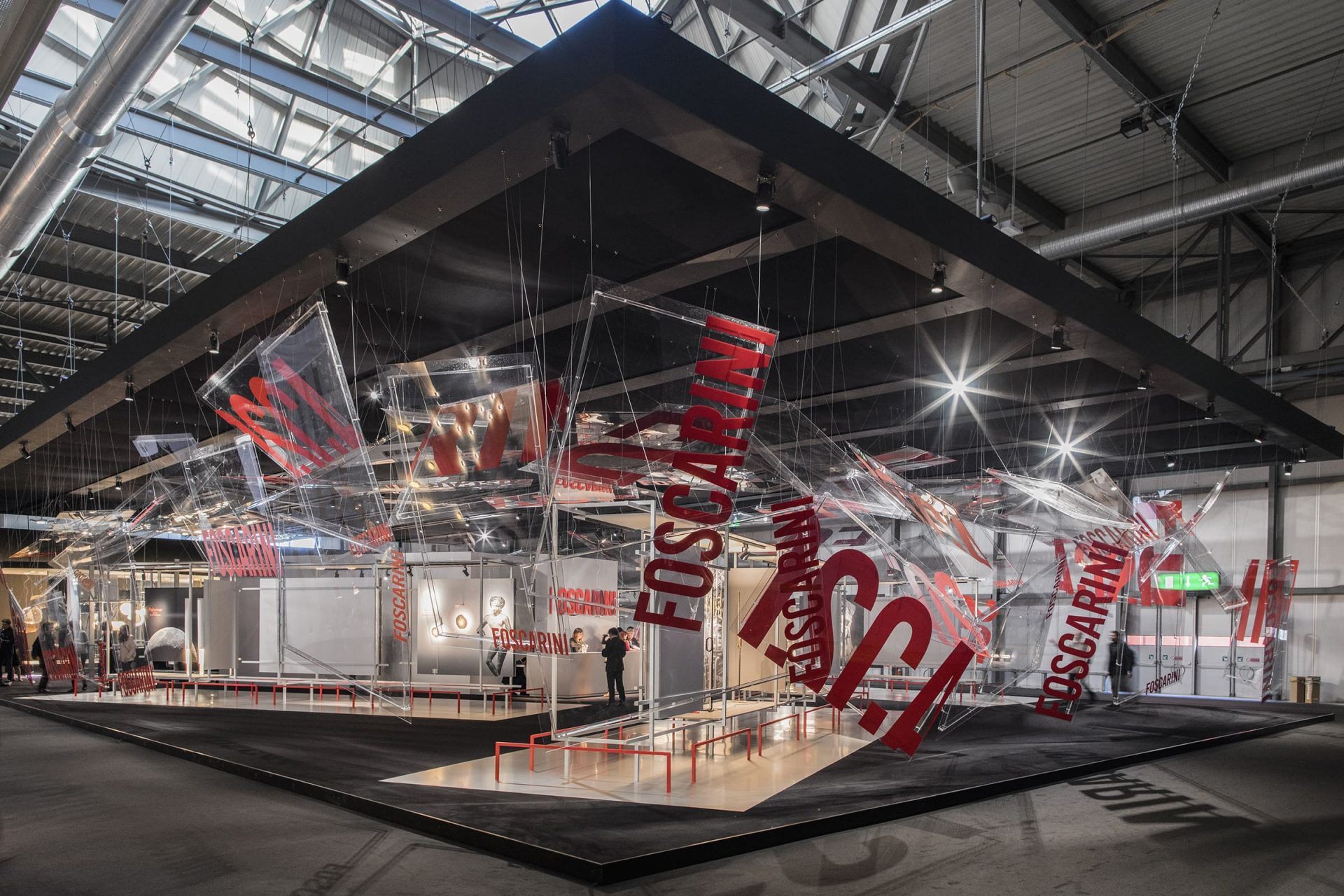 booth at Euroluce with Foscarini in red text printed on various squares suspended from the ceiling, displaying light systems and lamps