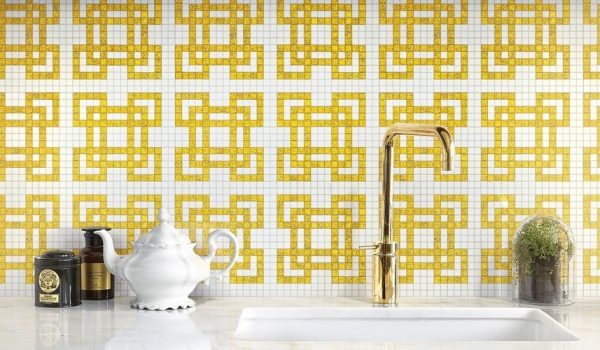 Italian Decorative wall tiles in the backsplash of a kitchen with a shining golden tap