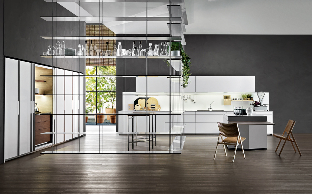 Vela kitchen by Dada kitchen a modern Italian kithchen brand presentented in a contemporary setting with Graduate library system hanging from the ceiling