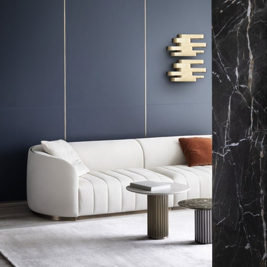 Italian style living room with a white sofa and blue wooden wall panelling with gold vertical stripes