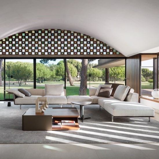 Italian style living room with molteni sofa by vincent van duysen and big windows on a very green private garden