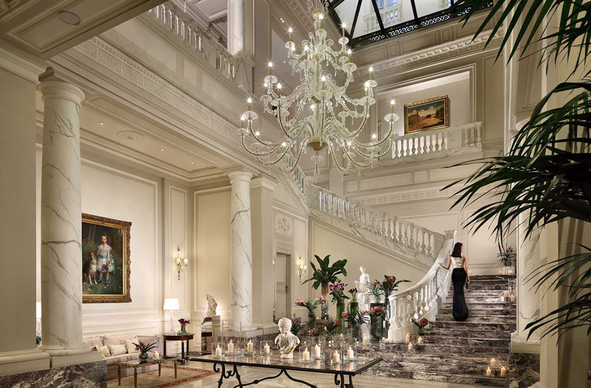 A winding Carrara Staircase and a crystal chandelier are the enchanting elements of this entrance to Palazzo Parigi Hotel & Grand Spa, one of most precious hotel in our list of the best five stars hotels in milan.